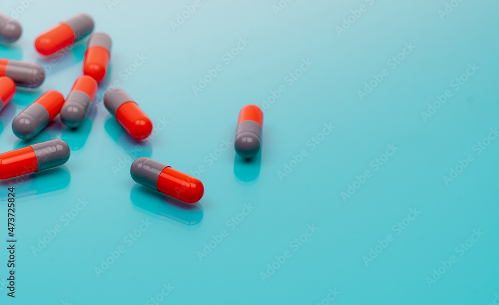 Wall mural orange and gray capsule pills on blue background. pharmaceutical industry. prescription drugs. healt