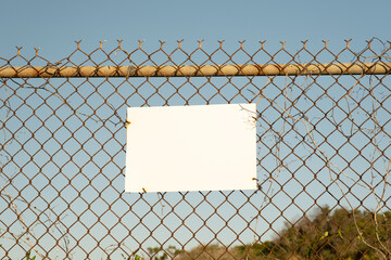 Blank White Sign with Fence and Blue Sky