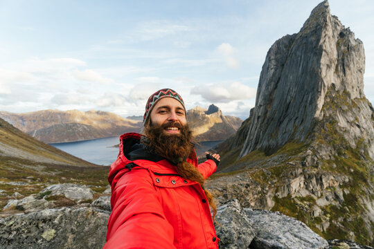 Smiling guy taking selfie near cliff