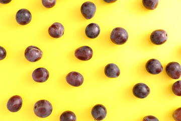 Red grapes isolated top view in yellow background