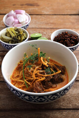 Local northern Thai food Egg noodle curry with beef on wood background