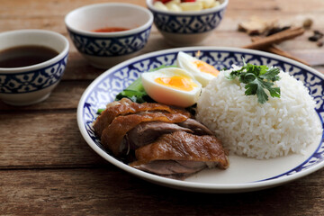 Local Thai food stewed pork leg on rice isolated in wood background