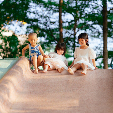 Asian Kids Playing Slide Outdoors