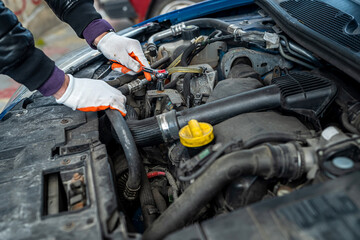 close up of mechanic hand using wrench to service car for repair or check engine