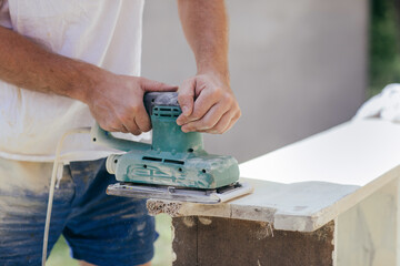 Anonymous man working with wood sander