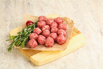 Raw uncooked beef meatballs served rosemary