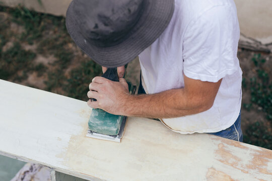 Man sanding old shelf 