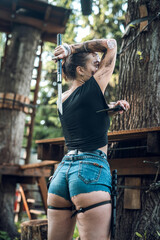 beautiful young girl in short shorts and a T-shirt smeared with swamp holds a dagger