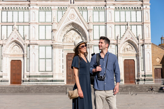 Smiling couple standing in front of Basilica Of Santa Croce on sunny day at Florence, Italy