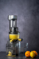 produce juice from oranges and lemons with a juice extractor. everything is photographed on a grey background