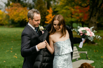 Groom Putting Jacket on Bride
