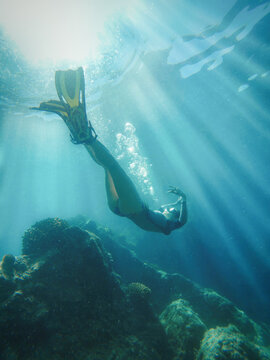 Female free diving in coral reef