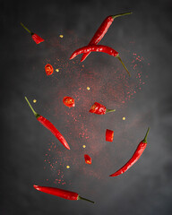 Levitation or flying of red chili pepper whole and slices with paprika powder used for food...