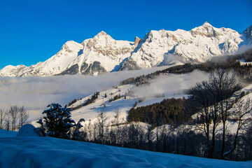 Fototapeta premium Winter landscape, stunning mountain range, snowy trees and blue sky at Maria Alm, Hinterthal in Austria