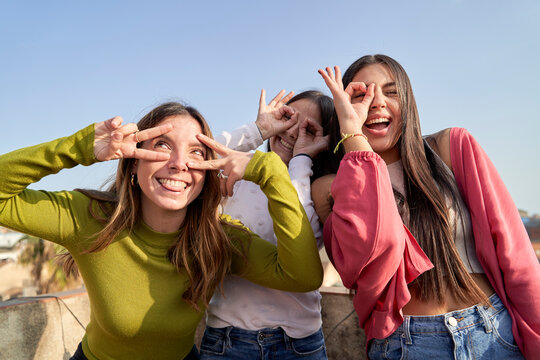 Funny female friends making faces while enjoying on terrace