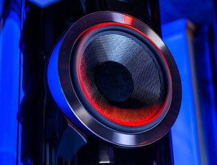 Mid-range driver of a home stereo system on a dark background. Red and blue contrast creative lighting. Abstract acoustic and music design. New Year's mood of celebration and fun.