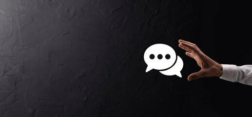 Businessman holding a message icon, bubble talk notification sign in his hands. Chat icon, sms icon, comments icon, speech bubbles