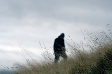 A moody figure blurred in the background