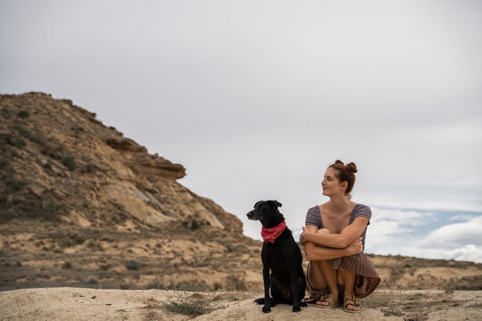 Woman and dog sitting and enjoying outdoors