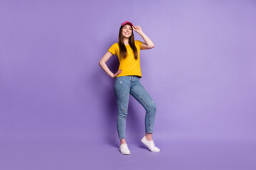 Fototapeta na wymiar Full body photo of happy positive cheerful young woman wear cap smile isolated on purple color background
