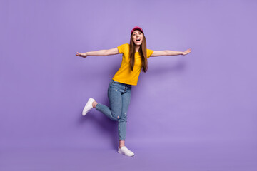 Full length photo of happy young positive woman hands plane wings wear cap isolated on purple color background