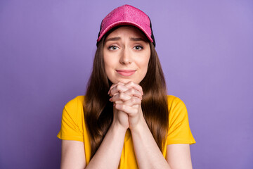 Photo of happy positive young woman hold hands together beg ask please desire isolated on purple...
