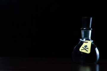 Obraz na płótnie Canvas vial of poison with a hazard warning label, on a dark background, toning, short focus