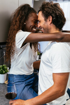 Cheerful couple kissing in kitchen