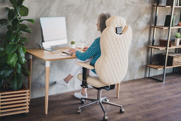 Profile side photo of aged business woman sit desk work remote browse computer chat type email indoors