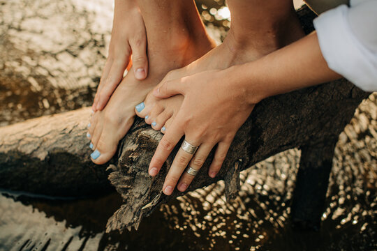 Female hands and feet, tree and water