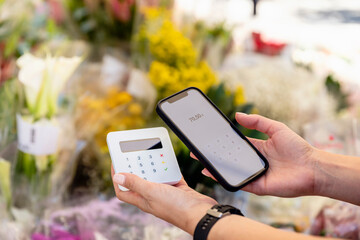 Woman doing contactless payment at flower shop
