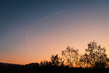 chemtrails at sunset with moon. colors and clear sky.