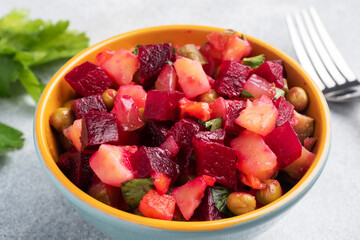 Vinaigrette with beetroot and boiled vegetables, traditional Russian homemade salad. Serving bowls with a cold snack on the table, copy space.