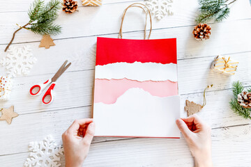 DIY Step-by-step guide instructions for Christmas paper bag for children. New year pack with Santa made of colored paper, glue and scissors. Fine motor skills. Winter holidays time. Handmade. Step 7