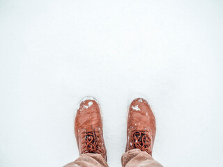 Time to buy winter shoes. Top view man standing in the snow. Boots in pure snow. Banner background with copy space