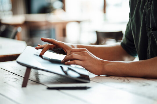 Young businessman using graphic tablet while working at cafe