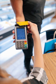 Woman paying through credit card to waitress at food court