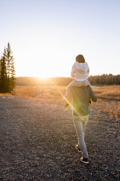 Father Walks With Daughter On Shoulders