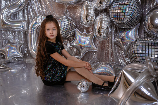 cute little child girl in black dress on confetti background