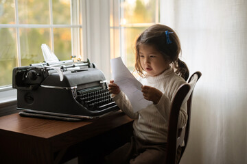 Child reading page from typewriter