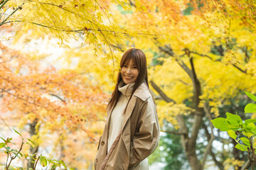 紅葉の公園にいる女性
