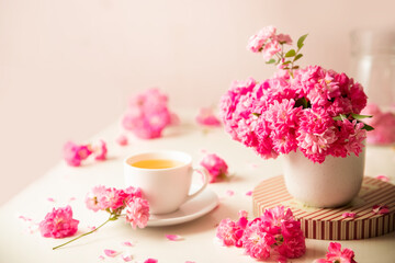 Obraz na płótnie Canvas roses and tea cup served for breakfast on plain background, copy space for text, valentine's day, wedding or anniversary morning decorations. 