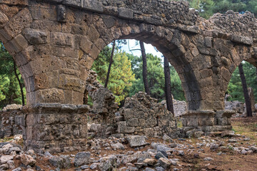 ruins of Roman aqueduct among the forest in the ancient city of Phaselis