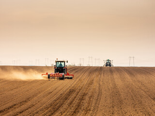 Tractor at agricultural farm field cultivating land