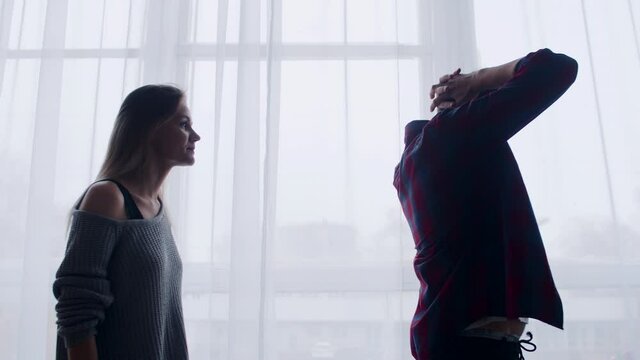 Young married couple quarreling in living room, shouting at each other emotionally gesticulating, side view. Husband squabble with wife at home, poking fingers each other, swearing and scream