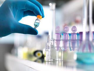 Cropped hand of scientist holding chemical formula in vial at laboratory