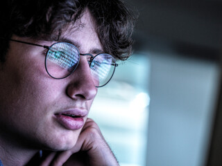 Worried teenage boy with reflection on eyeglasses