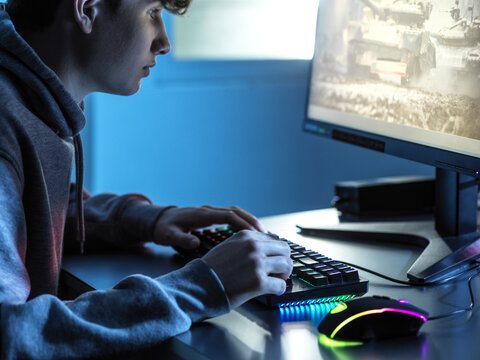 Boy Playing Online Game On Computer At Table