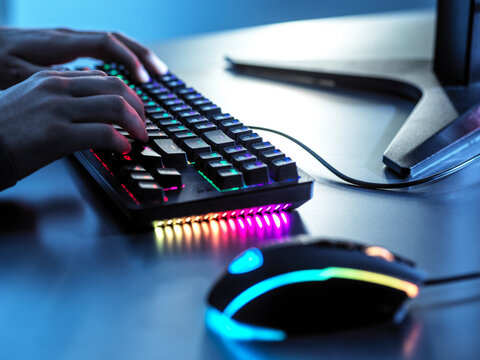 Boy playing game with illuminated keyboard on table