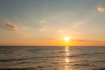 Fototapeta na wymiar beautiful sunrise on the horizon of the blue sea